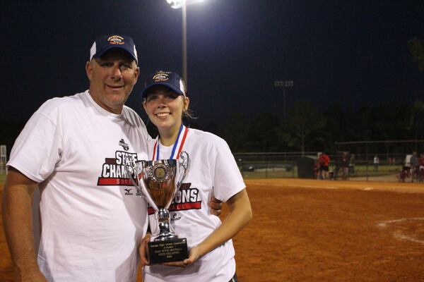 Katherine Grace McElhaney and her father Kevin pose with 2016 GHSA Class A Public softball state championship trophy won by Gordon Lee High. Katherine Grace won three state championships in softball with her father as an assistant coach and also played on basketball and tennis teams coached by her father. (Photo courtesy of the McElhaney family)