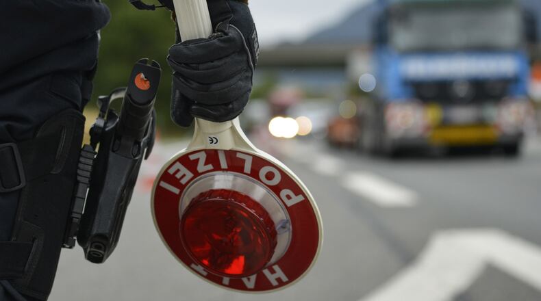 A German police officer holds a stop sign as he observes traffic Sept. 14, 2015, near Bad Reichenhall, Germany.