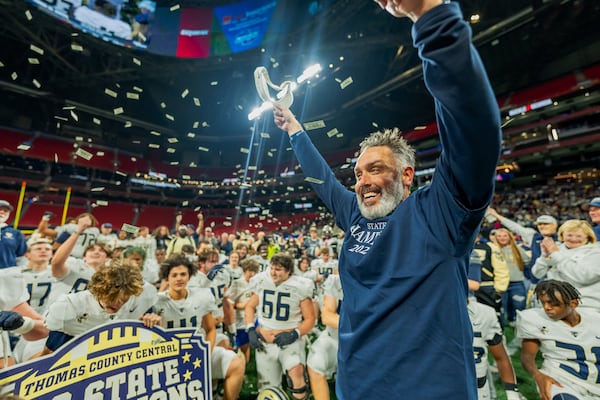 Thomas County Central coach Justin Rogers celebrates with his team on Wednesday, Dec. 13, 2023, after defeating Woodward Academy for the state title — the school's first since 1997. (Jason Allen for the AJC)