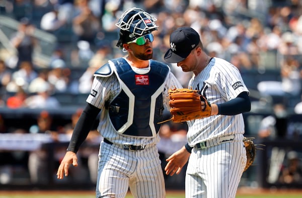 New York Yankees catcher J.C. Escarra and pitcher Clarke Schmidt chat during the seventh inning of a baseball game against the Baltimore Orioles, Saturday, June 21, 2025, in New York. (AP Photo/Noah K. Murray)