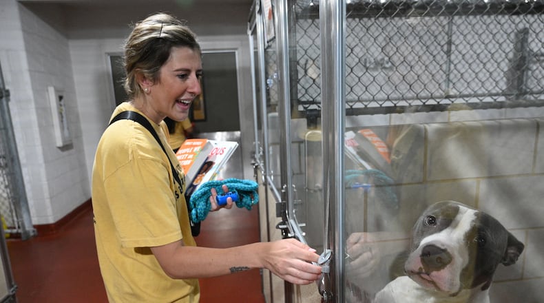 Camille Lillie (right) smiles as she checks rescue dogs at Cobb County Animal Services, Saturday, May 20, 2023, in Marietta. (Hyosub Shin / Hyosub.Shin@ajc.com)