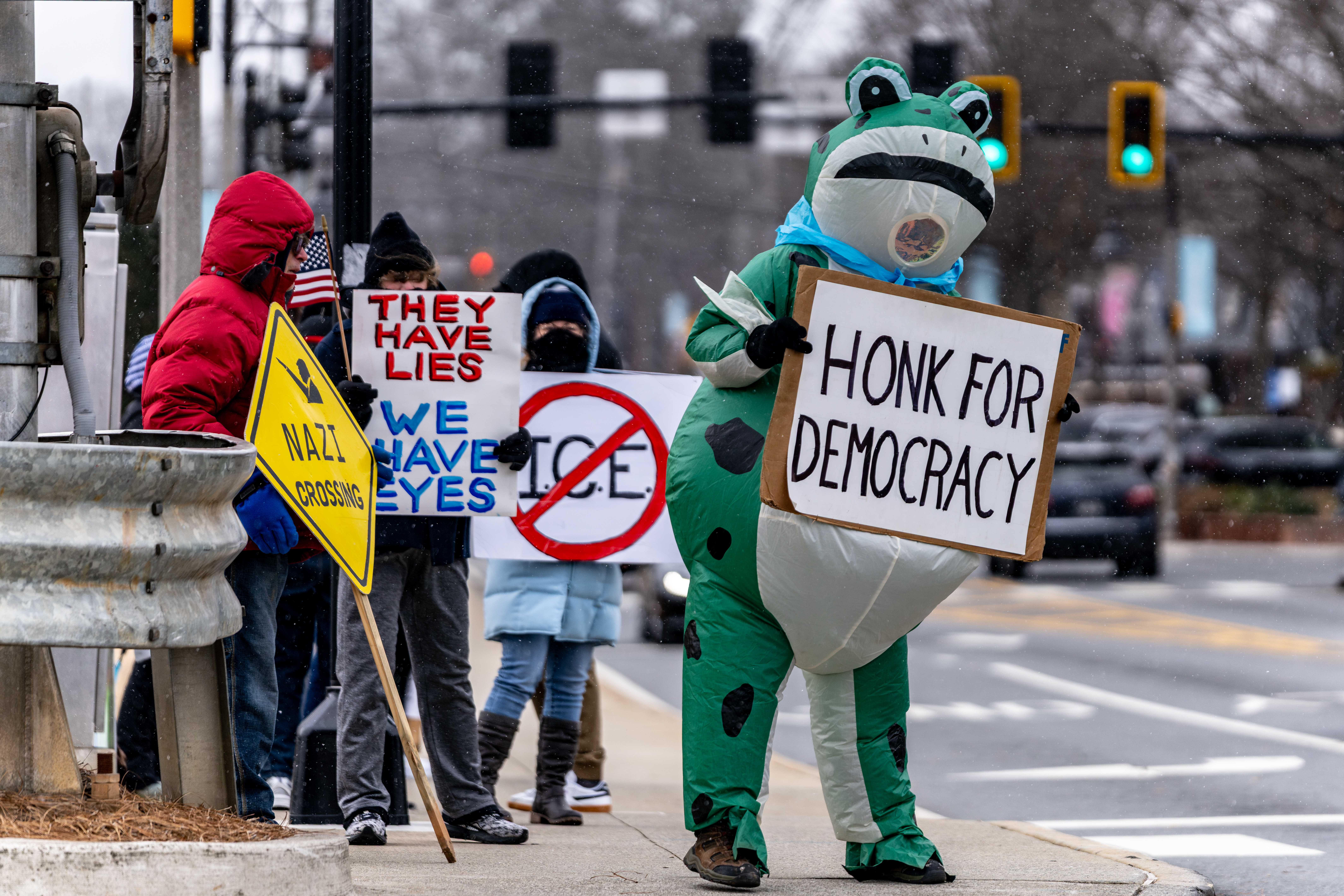Daniel Morris dressed in a frog costume protests Immigration and Customs Enforcement in downtown Woodstock, Georgia. Saturday, Jan 31, 2026. (Ben Hendren for the AJC)