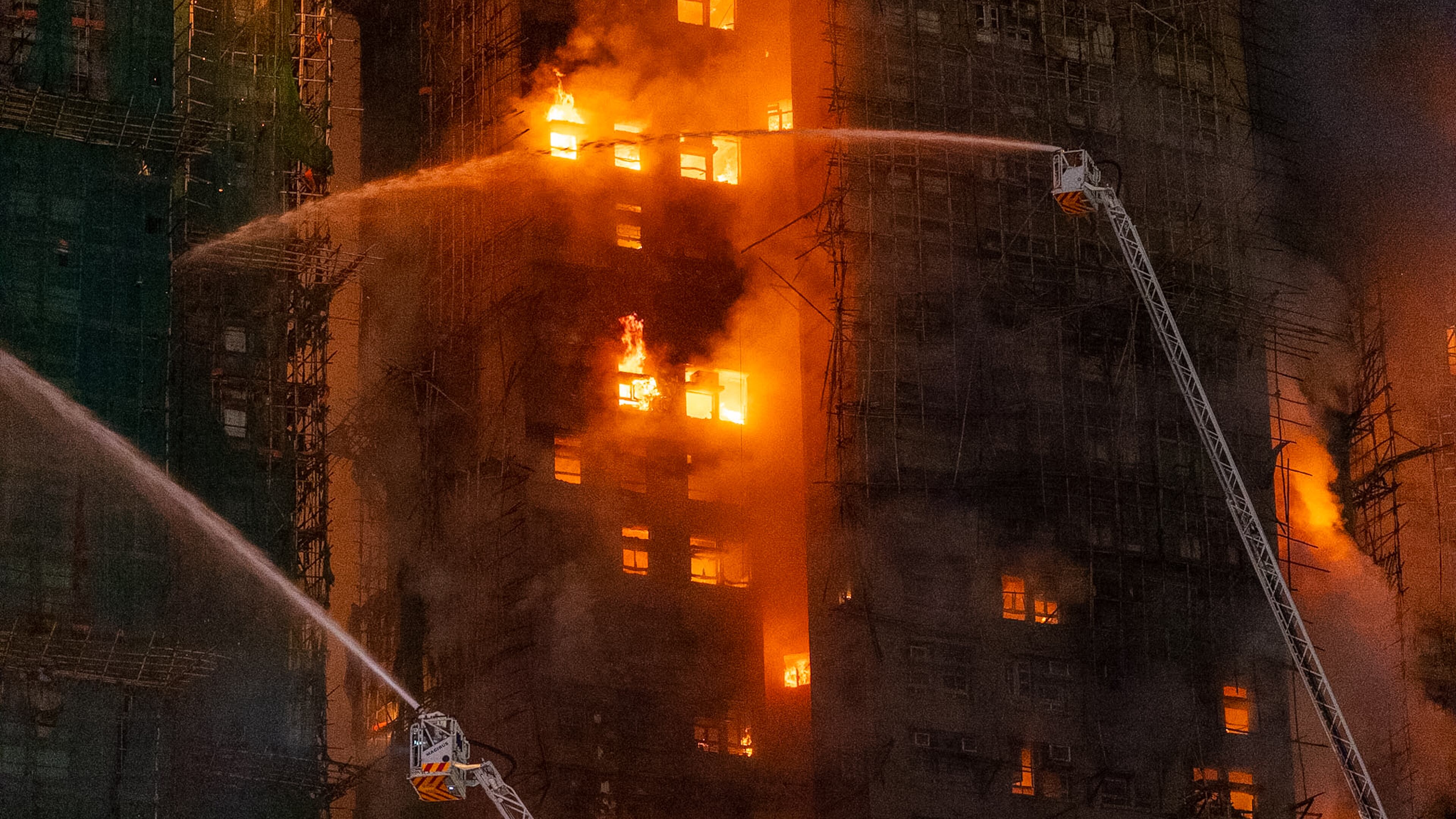Firefighters try to extinguish a flames engulfing a building after a fire broke out at Wang Fuk Court, a residential estate in the Tai Po district of Hong Kong's New Territories, Wednesday, Nov. 26 2025. (AP Photo/Chan Long Hei)
