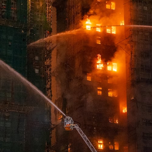 Firefighters try to extinguish a flames engulfing a building after a fire broke out at Wang Fuk Court, a residential estate in the Tai Po district of Hong Kong's New Territories, Wednesday, Nov. 26 2025. (AP Photo/Chan Long Hei)