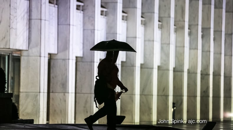 Shanell Rogers passes the Georgia Center on North Avenue at West Peachtree Street on a rainy Thursday morning.