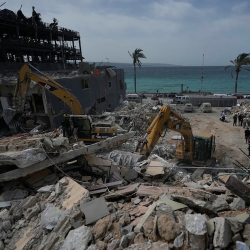 Rescuers search for victims in the rubble of a destroyed building that was struck in Israeli airstrikes in the city of Tyre, south Lebanon, Friday, April 17, 2026. (AP Photo/Mohammed Zaatari)