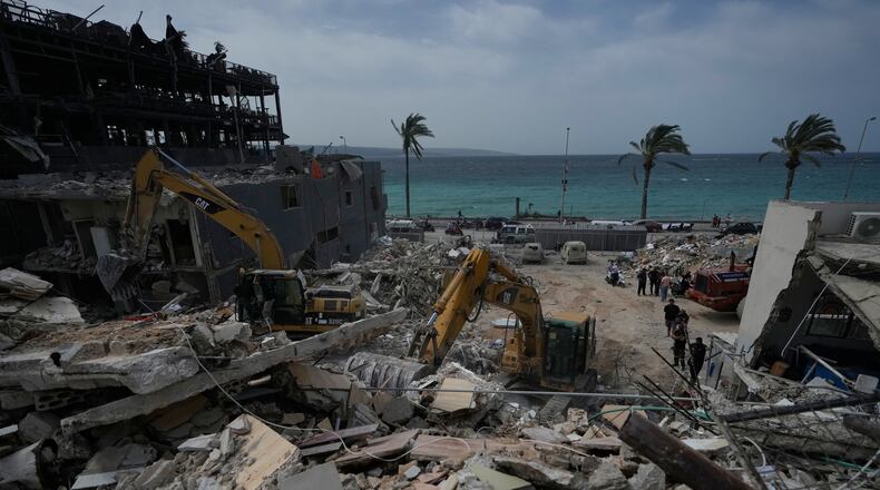 Rescuers search for victims in the rubble of a destroyed building that was struck in Israeli airstrikes in the city of Tyre, south Lebanon, Friday, April 17, 2026. (AP Photo/Mohammed Zaatari)