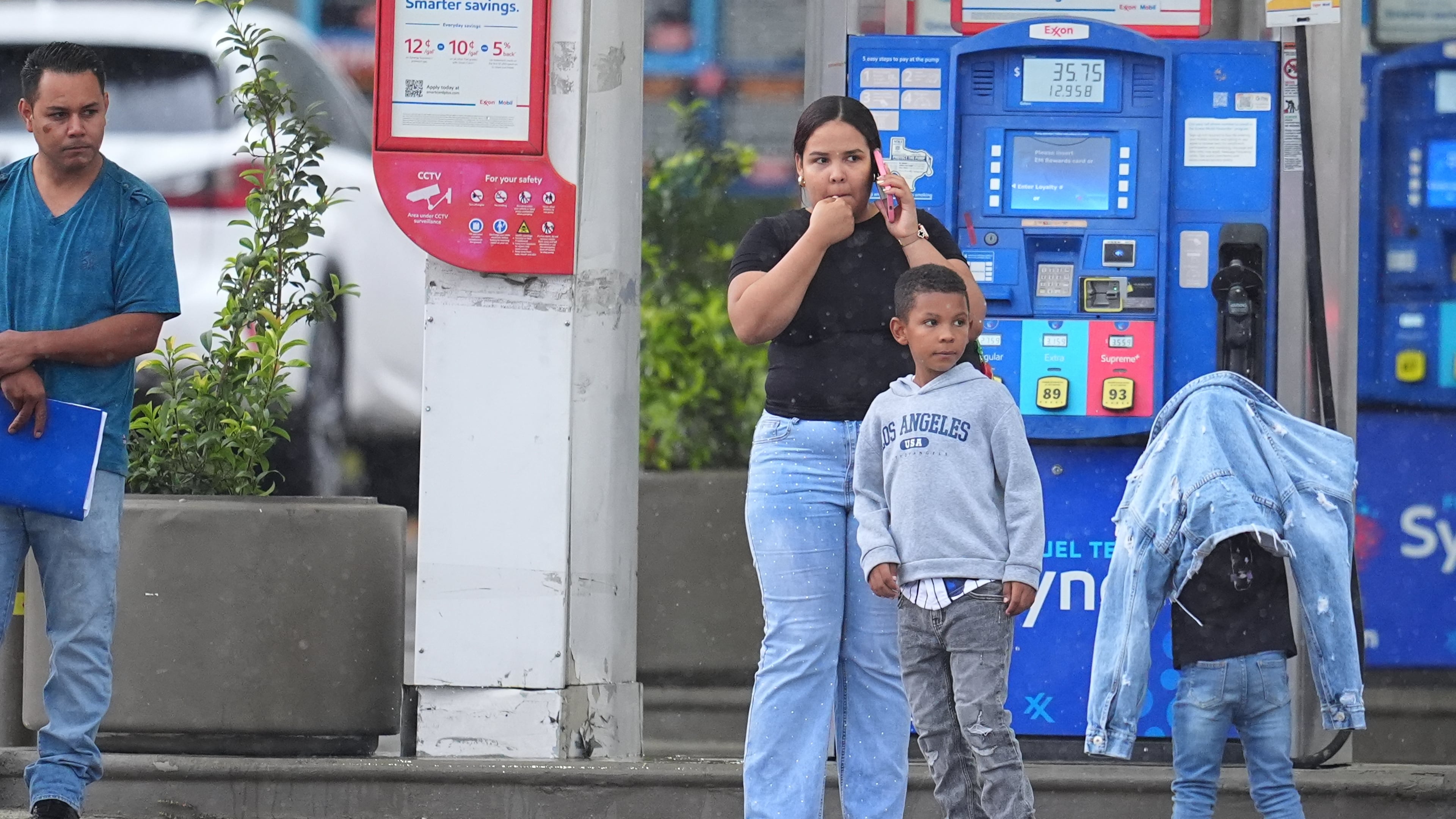 Edwin Cardona, left, who had an appointment at the U.S. Immigration and Customs Enforcement office, stands with his wife Arianny Sierra and their sons, after a shooting at the facility, in Dallas on Wednesday, Sept. 24, 2025. (AP Photo/Julio Cortez)