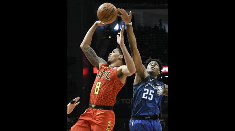 Atlanta Hawks guard Damion Lee shoots as Orlando Magic forward Wesley Iwundu (25) tries to get a hand on the ball during the first half of an NBA basketball game Sunday, April 1, 2018, in Atlanta.