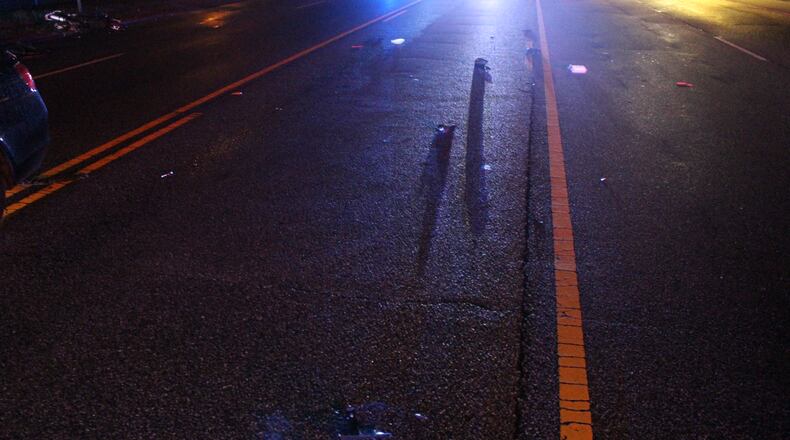 The impact threw the man from his motorcycle and he landed in the roadway.