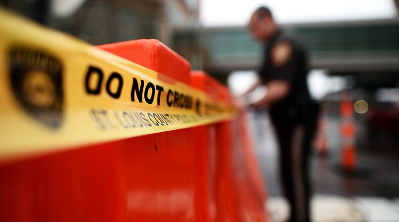A Georgia police official stretches police tape across a road barrier. A man in DeKalb County was just sentenced to life in prison for killing his new girlfriend in the middle of a busy intersection and leaving her for dead.