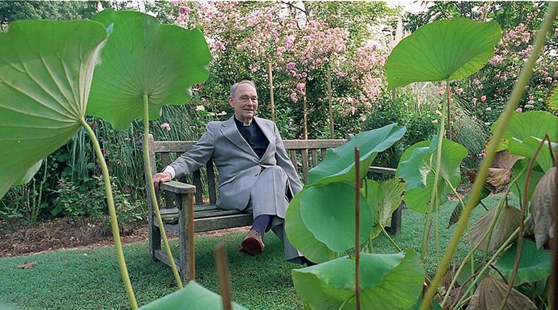 The Rev. Austin Ford, sits outside surrounded by plants in the garden of Emmaus House. (AJC file photo)
