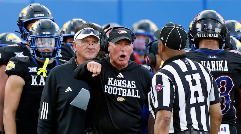 FILE - Kansas head coach Lance Leipold, center, disputes a call by an official during the first half of an NCAA collage football game against West Virginia Sept. 20, 2025, in Lawrence, Kan. (AP Photo/Colin E. Braley, File)