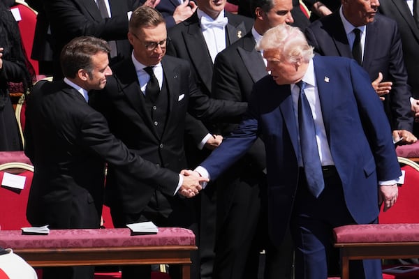 President Donald Trump, right, shakes hands with French President Emmanuel Macron, left, as Finland's President Alexander Stubb, looks on, as they attend the funeral of Pope Francis in St. Peter's Square at the Vatican, Saturday, April 26, 2025. (AP Photo/Evan Vucci)