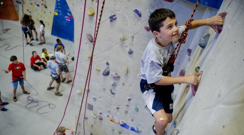 Aiden Levy (right) makes his way up a rock wall during climbing camp at the Stone Summit Climbing Center in Atlanta. JONATHAN PHILLIPS / SPECIAL