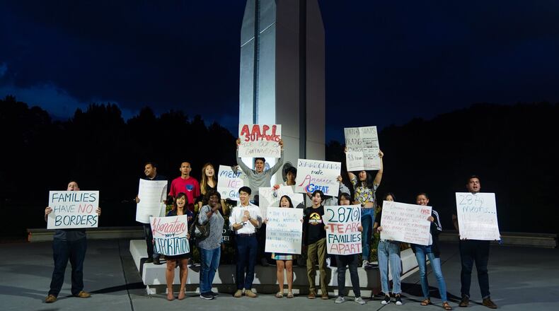 Opponents of the Immigration and Customs Enforcement agency’s 287(g) policy hold signs following a community engagement discussion on immigration organized by Gwinnett Commissioner Marlene Fosque at the Gwinnett Justice and Administration Center in Lawrenceville. ELIJAH NOUVELAGE/SPECIAL TO THE AJC