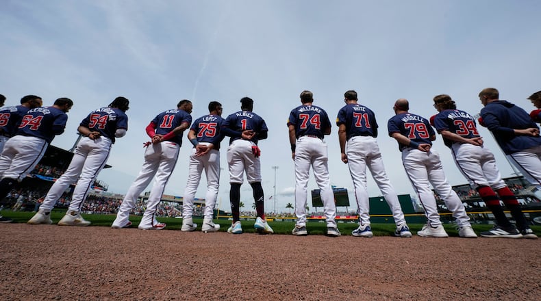 Atlanta Braves players line up for the national anthem before a spring training baseball game against the Detroit Tigers in North Port, Fla., Tuesday, March 5, 2024. (AP Photo/Gerald Herbert)