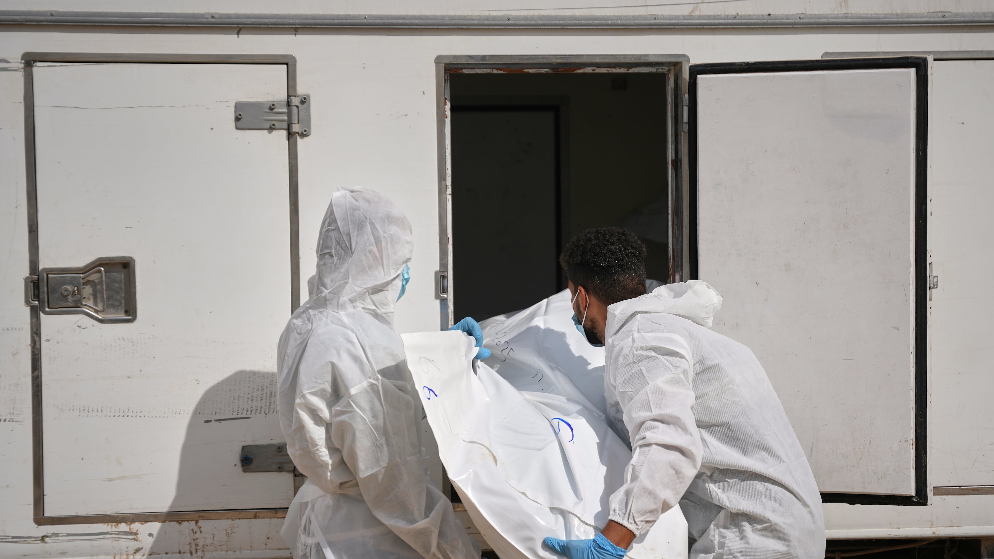 Bodies of unidentified Palestinians returned from Israel are taken into a vehicle to be buried in Nasser Hospital in Khan Younis, Gaza Strip, Friday, Nov. 14, 2025. (AP Photo/Abdel Kareem Hana)