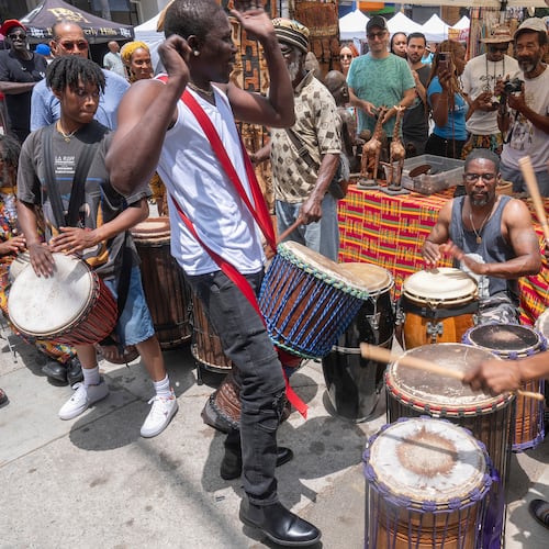 FILE - Drummers form a circle around Sika Dwimfo, better known as the, "Godfather of Leimert Park," during the neighborhood's Juneteenth celebration, June 19, 2024, at Leimert Park in Los Angeles. (AP Photo/Damian Dovarganes, File)