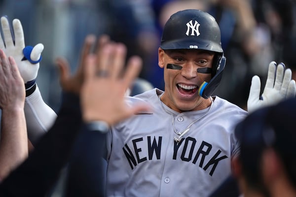 New York Yankees' Aaron Judge is congratulated by teammates in the dugout after hitting a solo home run during the first inning of a baseball game against the Los Angeles Dodgers, Friday, May 30, 2025, in Los Angeles. (AP Photo/Mark J. Terrill)