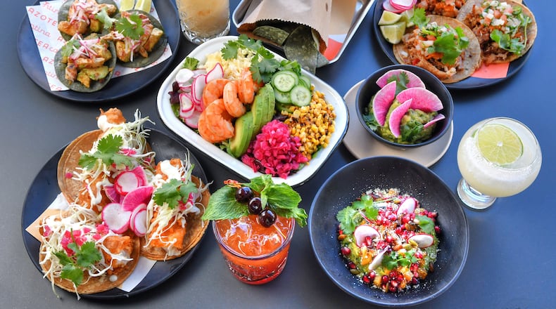 At Azotea Cantina at Atlantic Station, you can find (from top left going clockwise): Tostada de Pulpo, Sally from the Valley (cocktail), crispy corn totopos (chips served with dips), "Suadero" (tacos upper right), Azotea Margarita (frozen), guacamole with pomegranate and grilled pineapple, Cherry Bomb (cocktail), Baja Fish tacos (lower left), Azotea Salad with shrimp (center left), and guacamole. (Chris Hunt for The Atlanta Journal-Constitution)