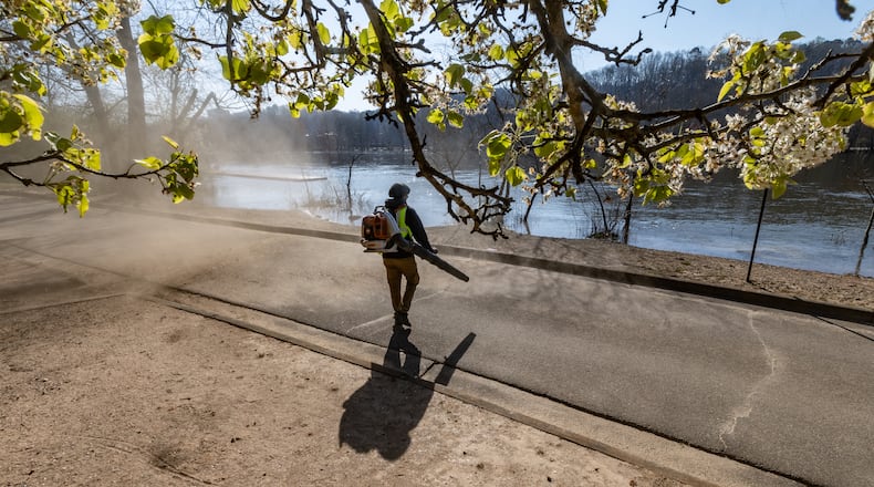 Orlando Echols of Roswell Parks and Recreation blows away flower pedals and dust from the parking lot at Azalea Park located in the 200 block of Azalea Drive in Roswell.  The pollen can worsen asthma symptoms and Atlanta Allergy & Asthma reported a pollen level that was the highest of the year - 1345 - on Monday, March 18.  (John Spink / John.Spink@ajc.com)