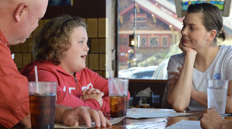 Chef Savannah Sasser (right) listens intently to 8-year-old Olivia Speaks, who hopes to become a chef one day. Also listening is Olivia’s father, Danny Speaks of Gainesville, Ga. (photo: HENRI HOLLIS)