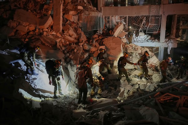 Israeli security forces inspect a destroyed building that were hit by a missile fired from Iran, near Tel Aviv, Israel, early Sunday, June 15, 2025. (AP Photo/Ohad Zwigenberg)