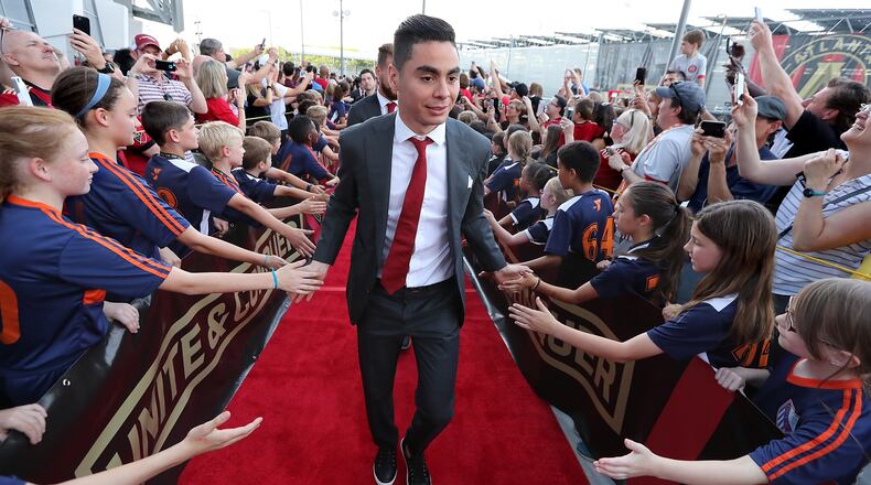 Atlanta United midfielder Miguel Almiron high fives fans during the team arrival at Mercedes-Benz Stadium to play Sporting Kansas City in a MLS soccer match on Wednesday, May 9, 2018, in Atlanta. Curtis Compton/ccompton@ajc.com