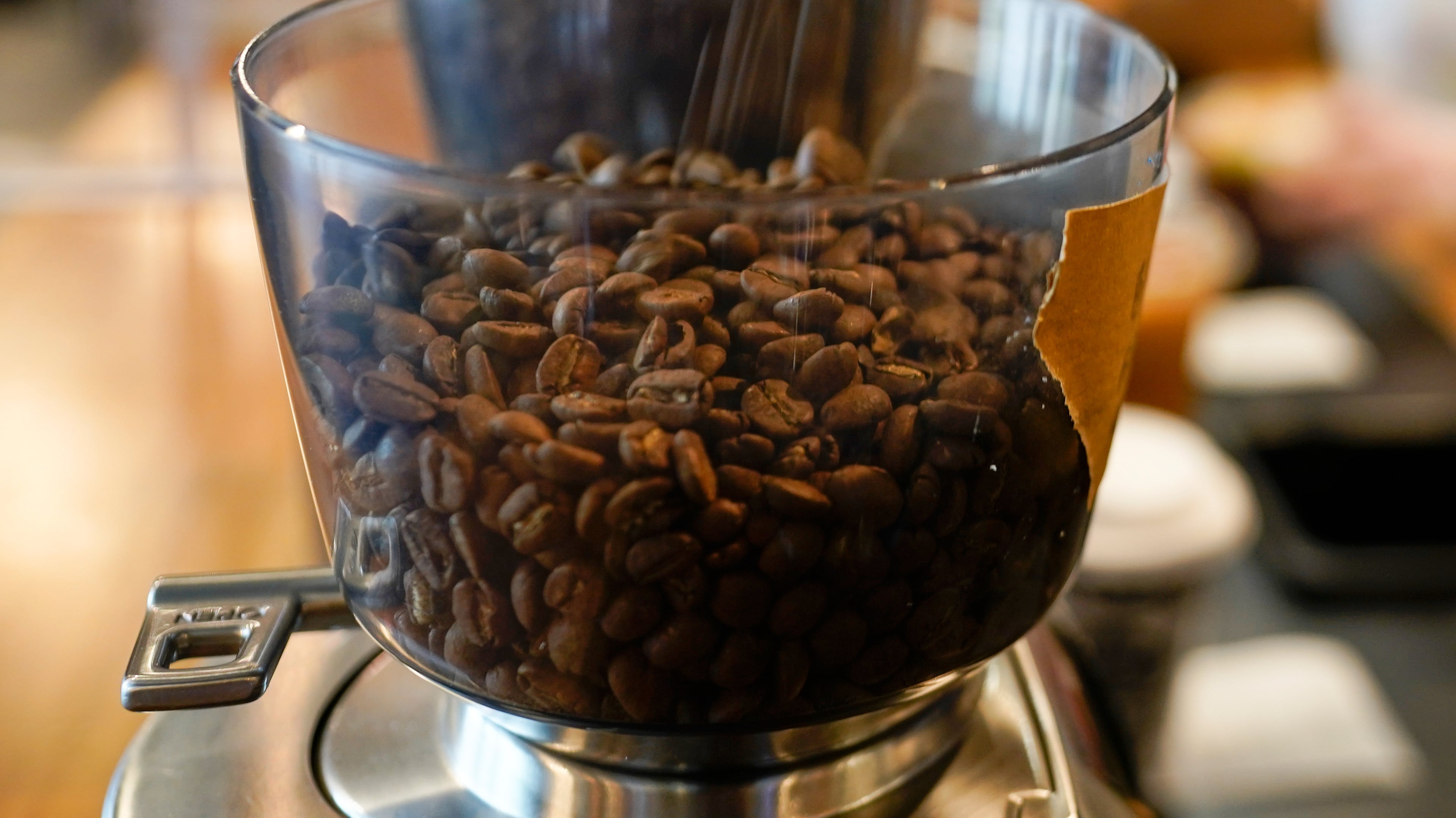 FILE - Coffee beans are poured into a grinder at a cafe in College Park, Md., on Wednesday, Sept. 1, 2021. (AP Photo/Julio Cortez, File)