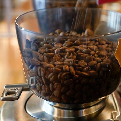 FILE - Coffee beans are poured into a grinder at a cafe in College Park, Md., on Wednesday, Sept. 1, 2021. (AP Photo/Julio Cortez, File)