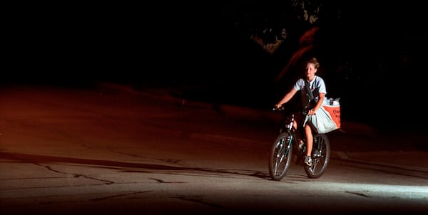 FILE - Christine Bartlett rides her bike between houses as she delivers The Journal Times early Tuesday morning, Aug. 28, 2001, in Racine, Wis. (Gregory Shaver/The Journal Times via AP)