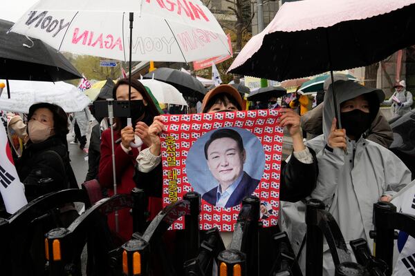 Supports of South Korea's ousted President Yoon Suk Yeol stand to call for the cancellation of his removal in front of the Seoul Central District Court in Seoul, South Korea, Monday, April 14, 2025. (AP Photo/Ahn Young-joon)