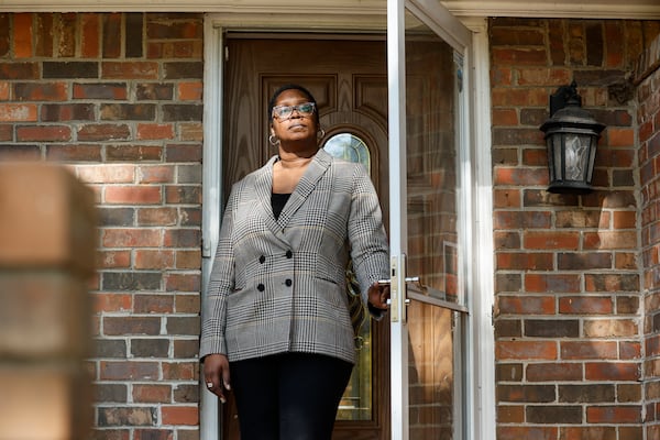 Dele Lowman, seen on her home's front porch in October, has rented two single-family homes in her Stonecrest neighborhood. Both were bought out of foreclosure by investment firms. Her current landlord, Ohio-based VineBrook Homes, bought them in early 2022 when it acquired the entire rental portfolio of nearly 3,000 homes nationwide from another private equity firm for $350 million. (Natrice Miller/natrice.miller@ajc.com)