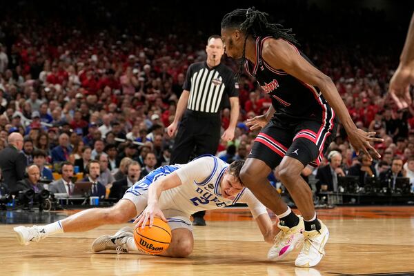 Duke forward Cooper Flagg slips as Houston forward Joseph Tugler looks on during the second half in the national semifinals at the Final Four of the NCAA college basketball tournament, Saturday, April 5, 2025, in San Antonio. (AP Photo/Brynn Anderson)