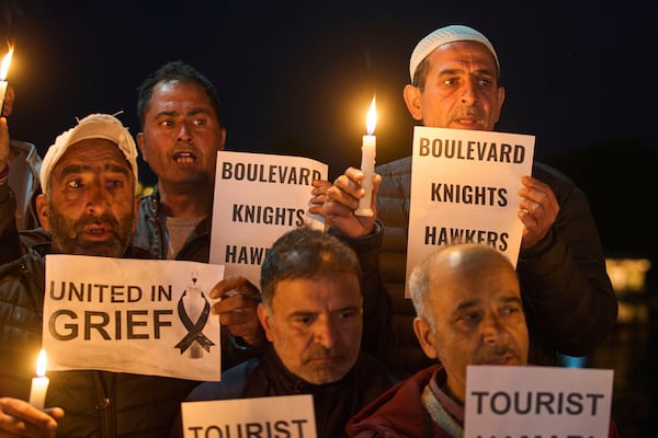 Kashmiri men hold candles and placards as they condemn the tourists killing during a protest in Srinagar, Indian controlled Kashmir, Thursday, April. 24, 2025. (AP Photo/Dar Yasin)