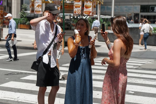 Woman takes a bite of an ice cream cone during a heatwave on Tuesday, June 24, 2025, in New York. (AP Photo/Olga Fedorova)