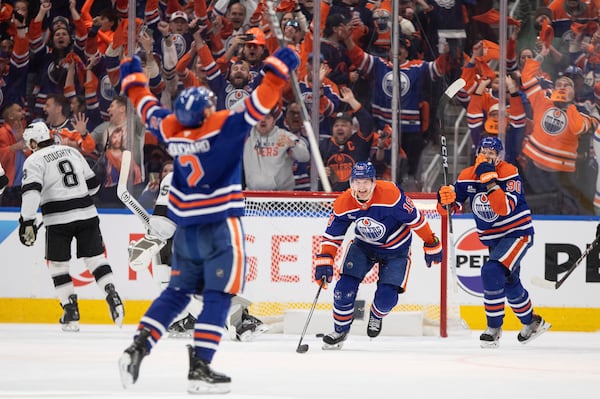Edmonton Oilers' Evan Bouchard (2), Zach Hyman (18) and Corey Perry (90) celebrate a goal against the Los Angeles Kings during the third period of an NHL playoff game in Edmonton on Sunday, April 27, 2025. (Jason Franson/The Canadian Press via AP)