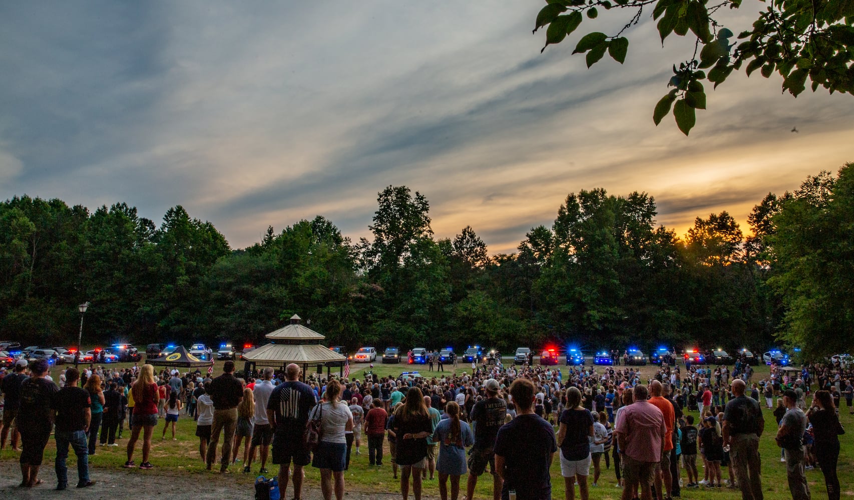Members of the Holly Springs community and neighboring police departments gather at Barrett Park for a candlelight vigil for Police Officer Joe Burson on Friday, June 18, 2021 after he was killed during a traffic stop earlier this week.(Jenni Girtman for The Atlanta Journal-Constitution)