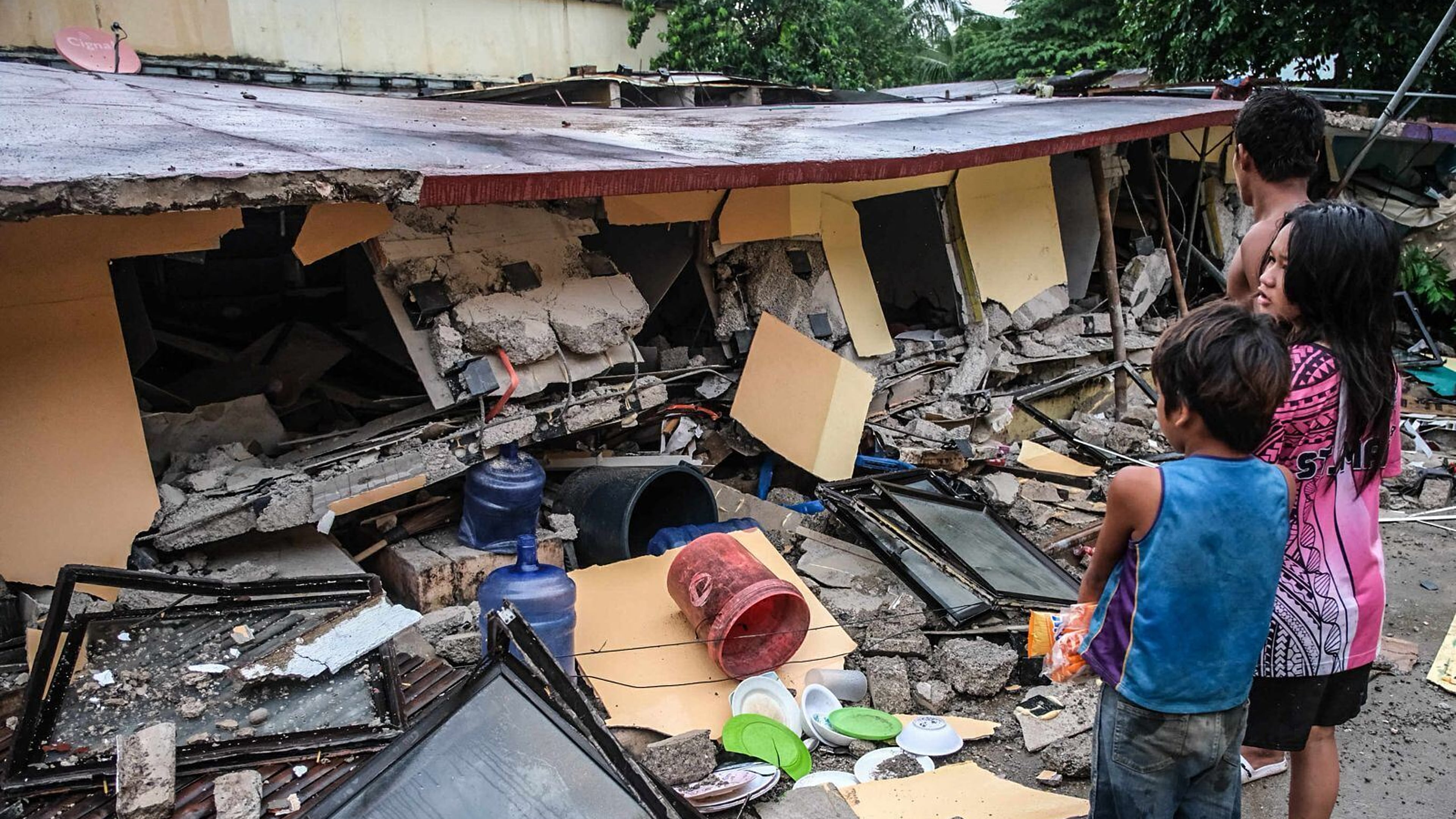 People look at a collapsed building in Bogo City, Cebu province, Philippines Wednesday, Oct. 1, 2025 after an offshore earthquake on late Tuesday. (AP Photo)