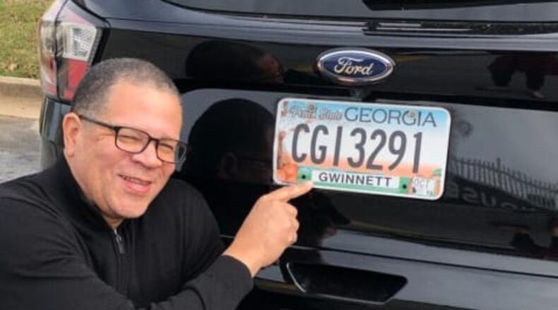 Former Fulton County Commission Chairman John Eaves points to his license plate to show he now lives in Gwinnett County, where he’s running in the 7th Congressional District. Some U.S. House candidates in metro Atlanta are drawing criticism from rivals because they don’t live within the districts they hope to represent in Congress.