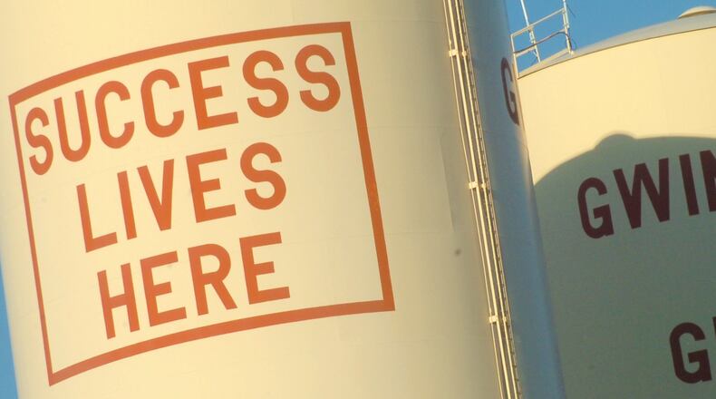 This 2007 file photo shows the former I-85 water towers that said “Gwinnett is Great” and “Success Lives Here.” The Water Tower project, under construction in Buford, is named after the water towers that were torn down. AJC FILE PHOTO