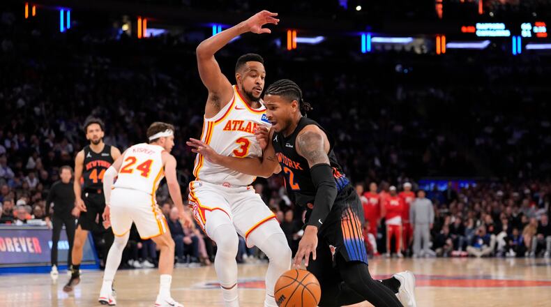 New York Knicks guard Miles McBride (2) drives past Atlanta Hawks guard CJ McCollum (3) during the first half in Game 2 of a first-round NBA playoffs basketball series, Monday, April 20, 2026, in New York. (AP Photo/Yuki Iwamura)