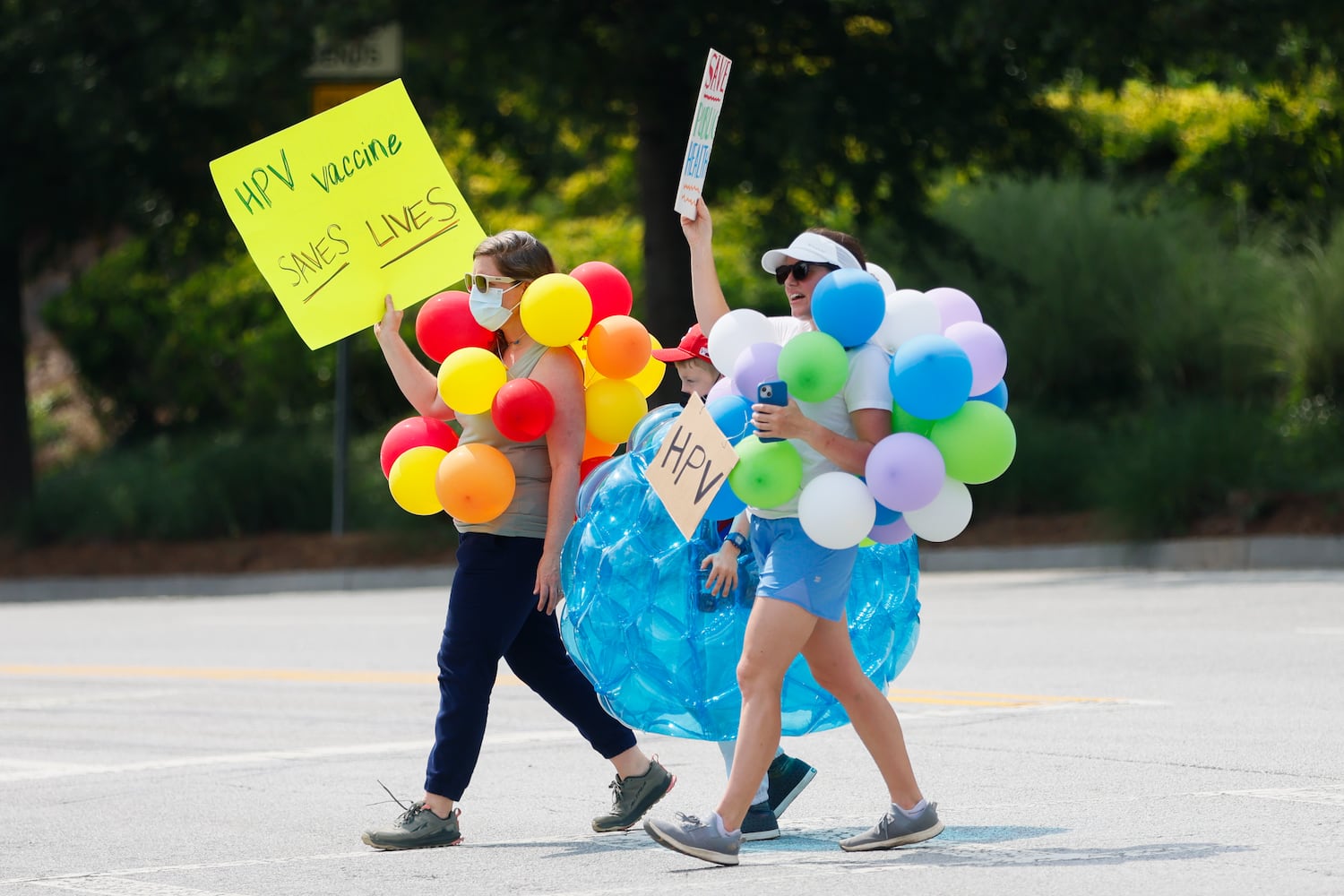 Protestors walk across the street dressed as ‘preventable diseases’ outside of the CDC in Atlanta on Wednesday, June 25, 2025. As Health and Human Services Secretary Robert F. Kennedy Jr. purged and reconstituted CDC vaccine advisory panel, ACIP, convenes for the first time, CDC advocates gather to protest on the dangers to health. (Abbey Cutrer / AJC)
