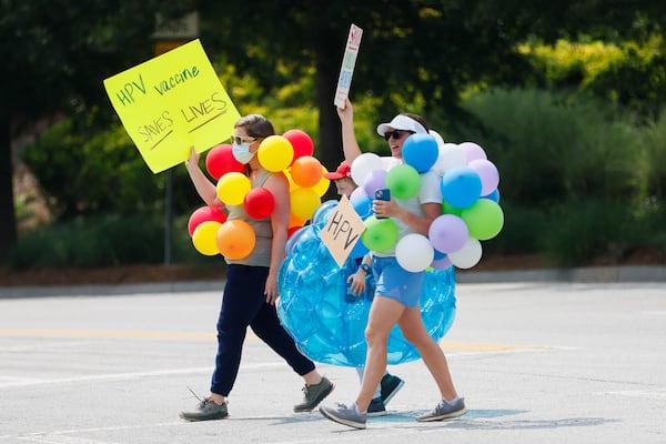 Protestors walk across the street dressed as ‘preventable diseases’ outside of the CDC in Atlanta on Wednesday, June 25, 2025. (Abbey Cutrer/AJC)