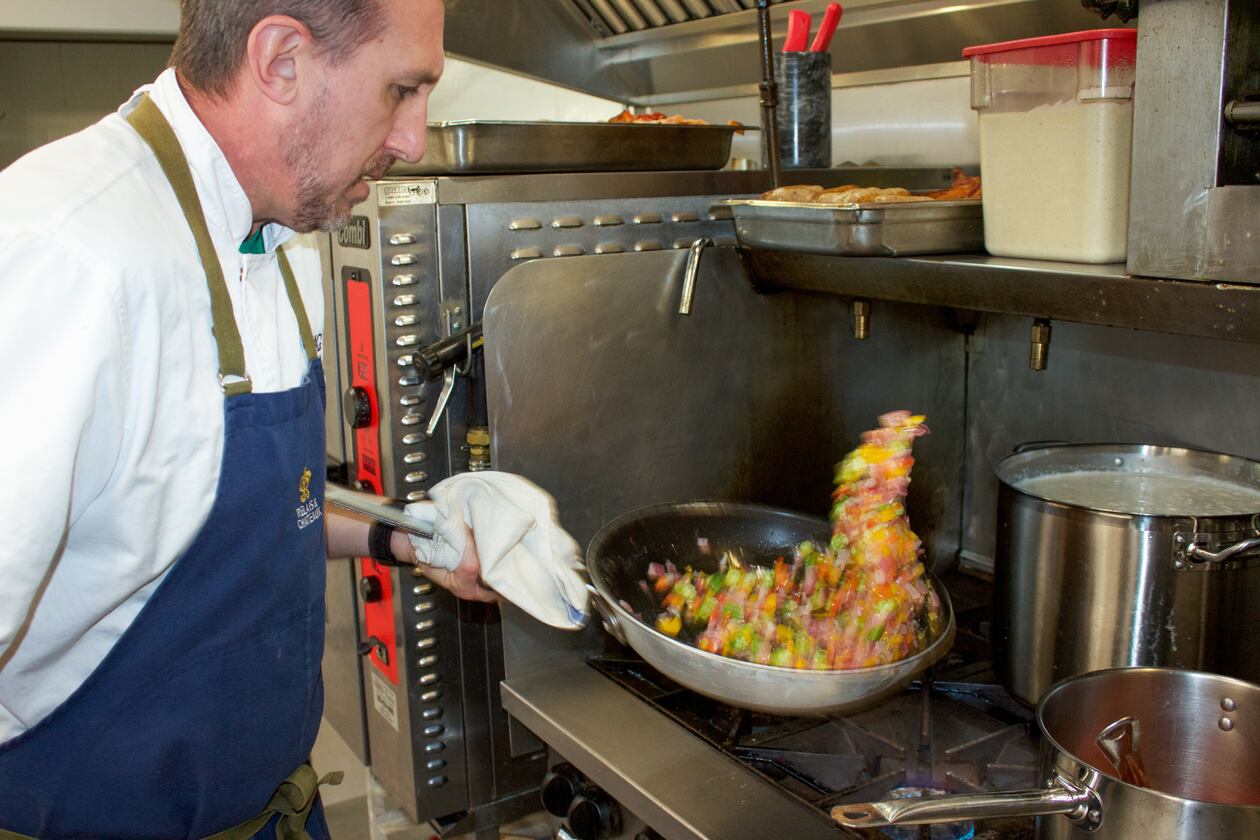 Chef Jake Schmidt of the Swag, a resort in Waynesville, North Carolina, prepares breakfast succotash with tomato gravy. The dish frequently changes to showcase seasonal, locally grown produce. (Courtesy of Becky Seymour)