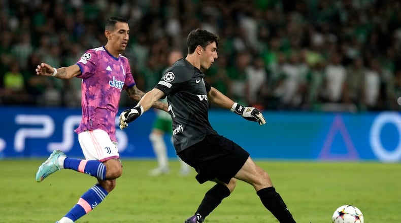 Maccabi's goalkeeper Josh Cohen kicks the ball as Juventus' Angel Di Maria tries to stop him during the group H Champions League soccer match between Maccabi Haifa and Juventus at Sammy Ofer stadium, in Haifa, Israel, Tuesday, Oct. 11, 2022. (AP Photo/Ariel Schalit)