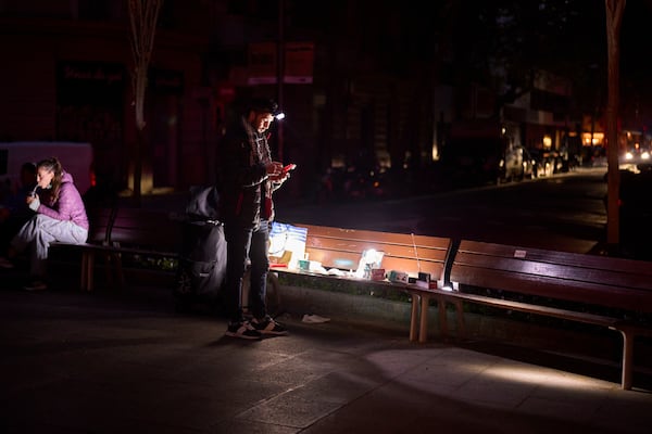 A man sells battery-powered radios and torches on a Barcelona street during the blackout in Barcelona, Spain, Tuesday, April 29, 2025. (AP Photo/Emilio Morenatti)