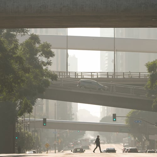 FILE - A person crosses a street as pollution fills the air, Dec. 4, 2024, in Los Angeles. (AP Photo/Andy Bao, File)