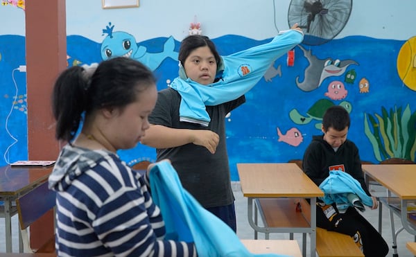 Students put on uniforms at a school for victims of Agent Orange in Da Nang, Vietnam, March 7, 2025. (AP Photo/Hau Dinh)